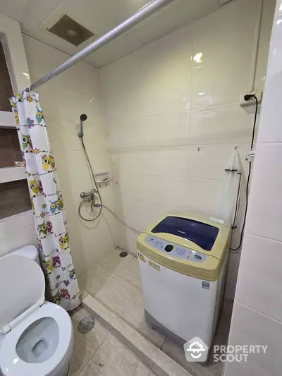 Compact bathroom with washing machine and shower area