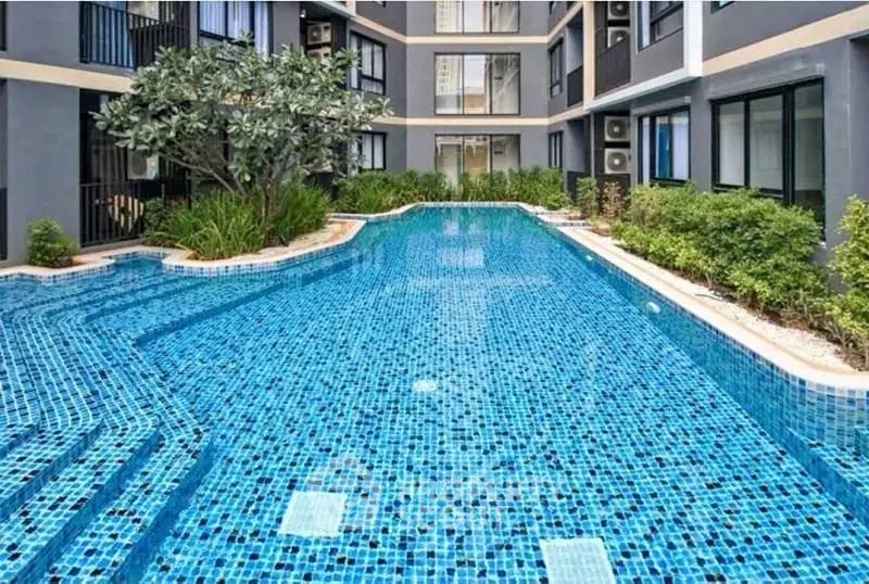 Luxurious residential building with a stunning outdoor pool and lush greenery.