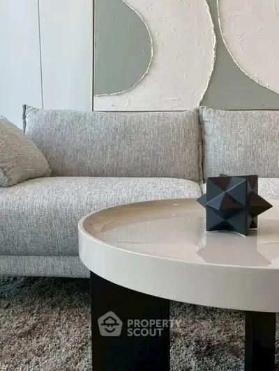 Modern living room with stylish sofa and geometric decor on coffee table.