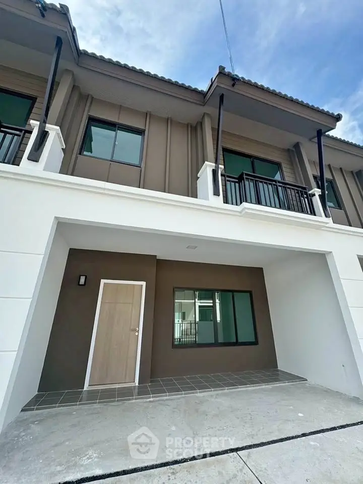 Modern townhouse exterior with balcony and garage, perfect for urban living.