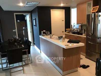 Modern kitchen with sleek cabinetry and dining area in contemporary apartment