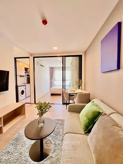 Modern living room with open layout, cozy sofa, and stylish decor in a contemporary apartment.