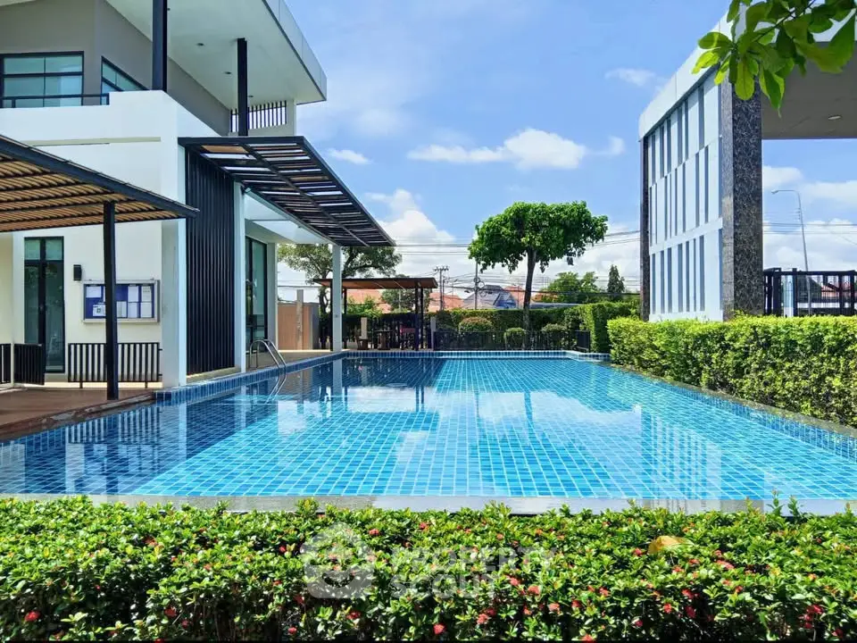 Luxurious modern home with stunning outdoor pool and lush greenery, perfect for relaxation and entertainment.