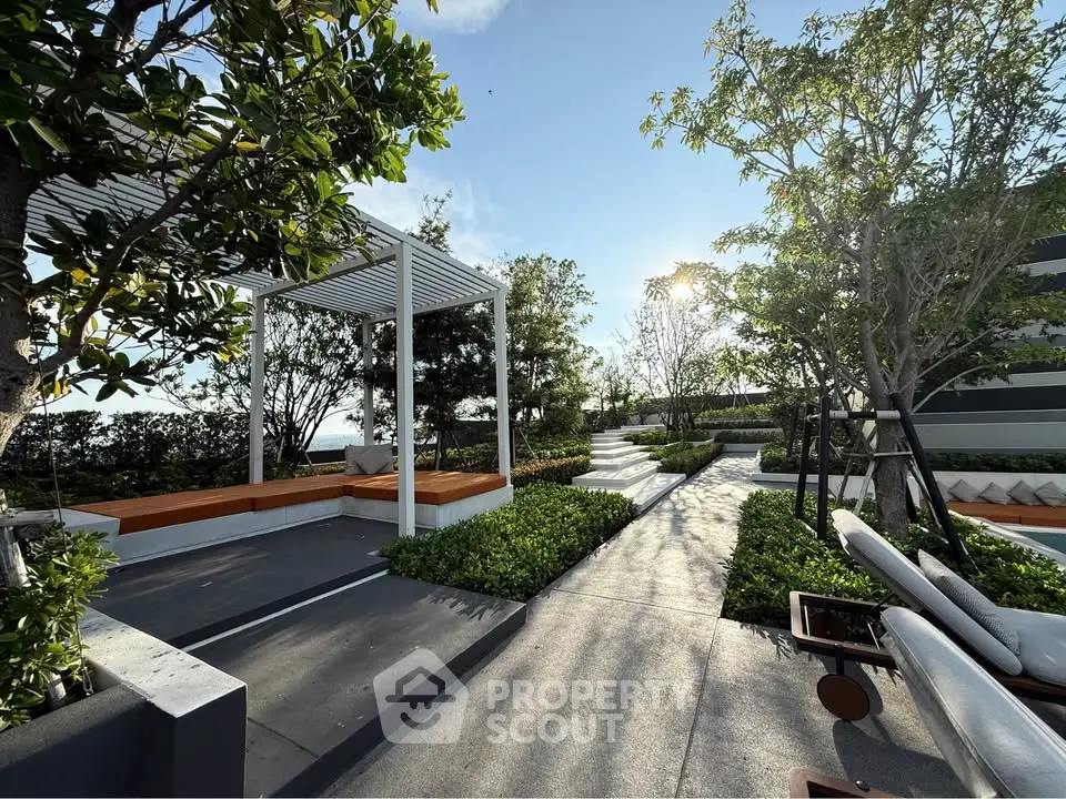 Luxurious rooftop garden with modern seating and lush greenery under a clear blue sky.