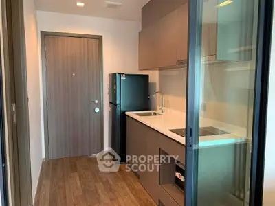 Modern compact kitchen with sleek cabinetry and integrated appliances in a stylish apartment.