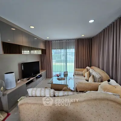 Spacious living room with cozy sofas and large window view in modern apartment.