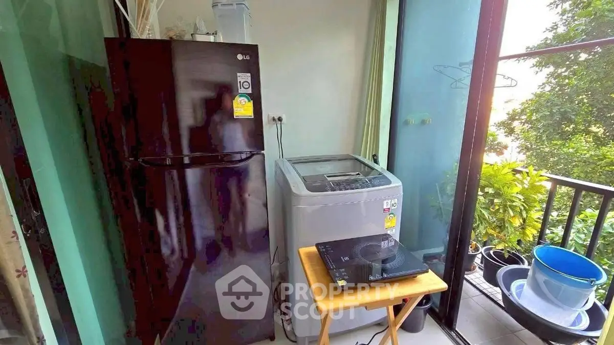 Compact balcony with fridge, washing machine, and lush greenery view