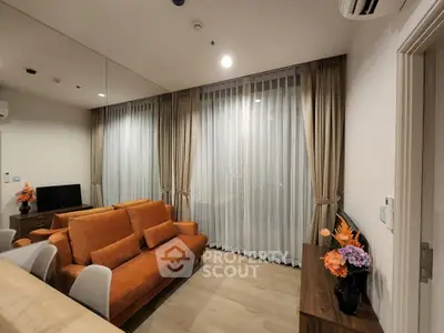 Modern living room with orange sofa, elegant curtains, and stylish decor in a cozy apartment.