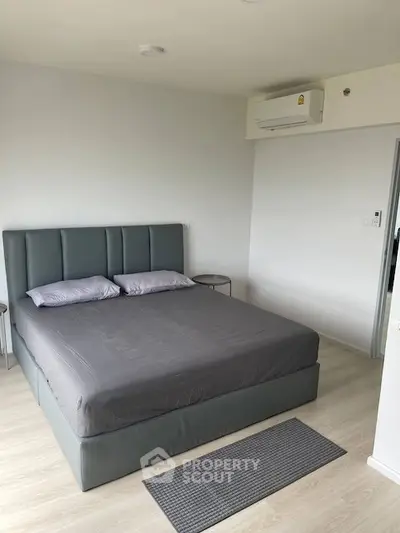 Modern bedroom with sleek design and air conditioning in a contemporary apartment.
