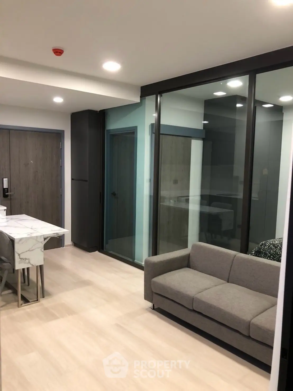 Modern living room with sleek design and glass partition in a contemporary apartment.