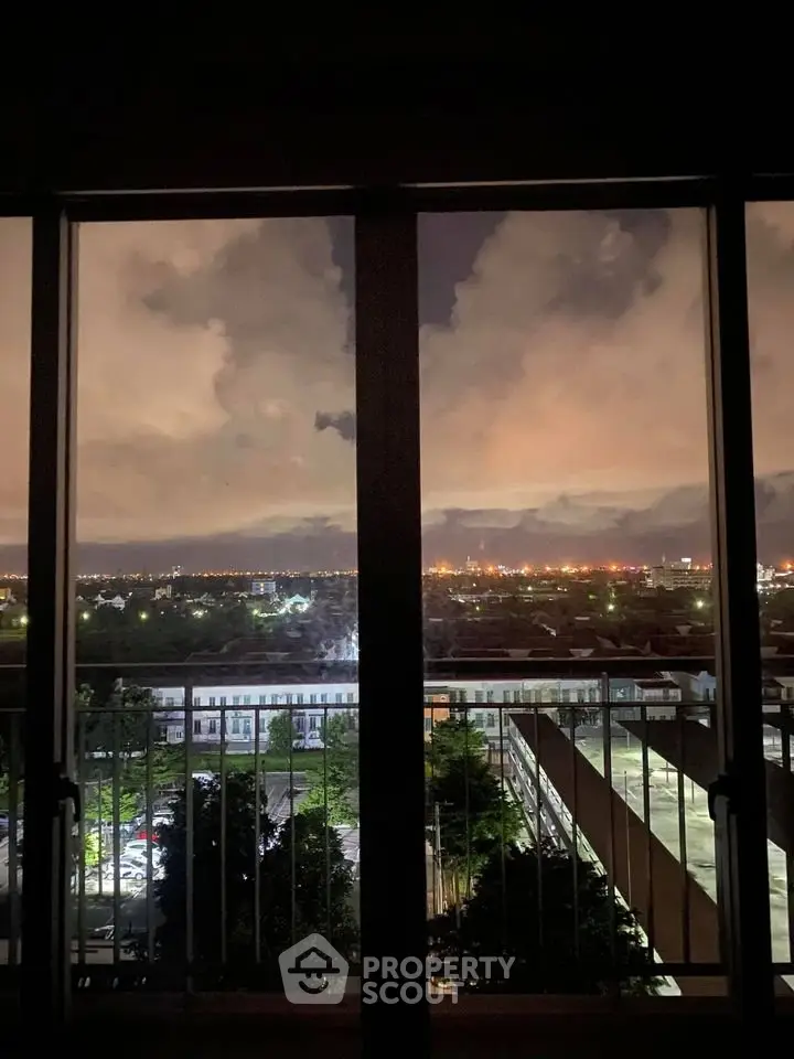 Stunning night cityscape view from a high-rise balcony, showcasing urban lights and expansive skyline.