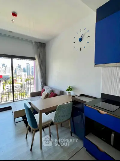 Modern living room with city view and stylish blue kitchen cabinets