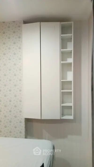 Cozy bedroom with modern white storage cabinets and floral wallpaper