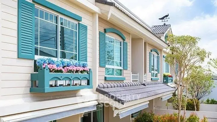 Charming townhouse exterior with colorful window boxes and elegant shutters.