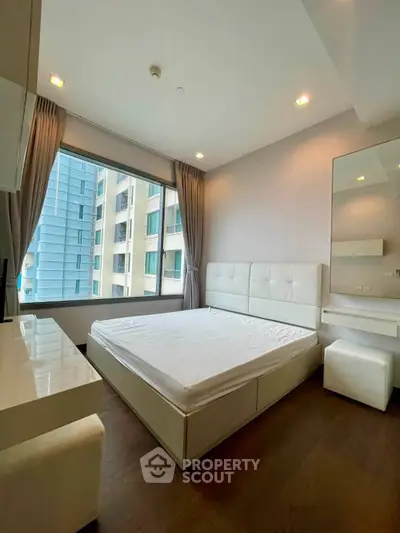 Modern bedroom with large window and stylish furniture in high-rise apartment
