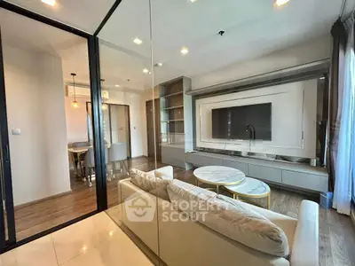 Modern living room with glass partition, sleek furniture, and open dining area in a stylish apartment.