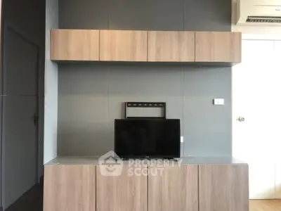 Modern living room with sleek wooden cabinetry and mounted TV, perfect for contemporary living.
