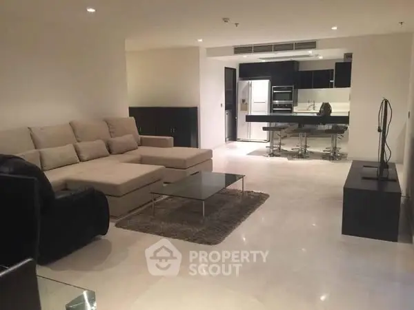 Spacious modern living room with open kitchen and elegant furnishings.