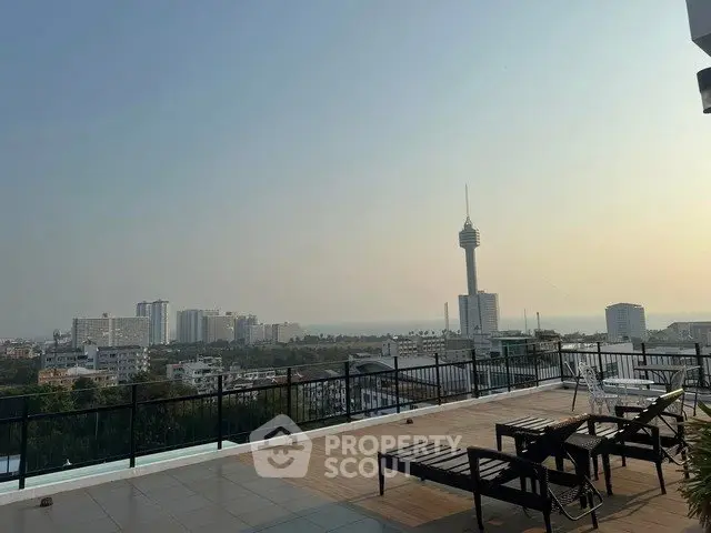 Stunning rooftop view with cityscape and distant ocean horizon, perfect for relaxation and leisure.