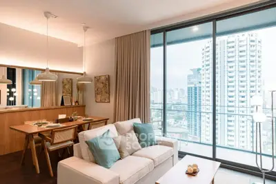 Luxurious living room with stunning city view and elegant dining area in modern apartment.