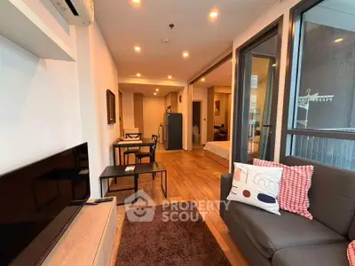 Modern open-plan living room with cozy seating and dining area, featuring stylish decor and ample natural light.