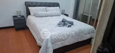 Cozy bedroom with modern decor and neatly arranged bed linens, perfect for relaxation.