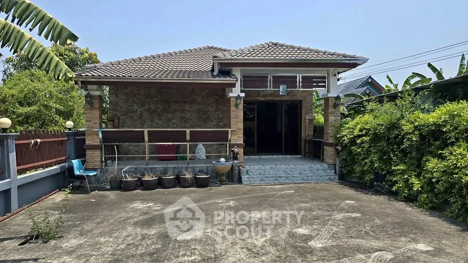 Charming single-story home with spacious driveway and lush greenery, perfect for serene living.