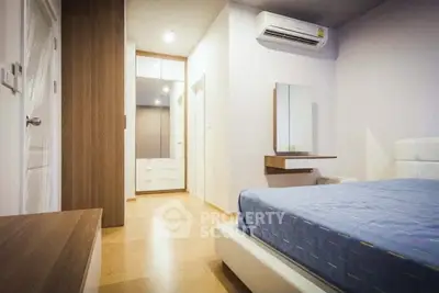 Modern bedroom with sleek design, featuring wooden flooring and built-in storage solutions.