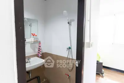 Compact bathroom with shower and sink in modern apartment