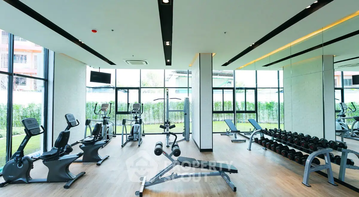 Modern gym with state-of-the-art equipment and large windows for natural light.