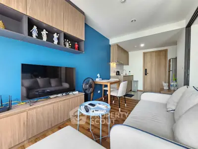 Modern living room with blue accent wall, stylish wooden cabinets, and cozy seating area.