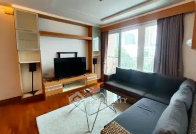 Spacious living room with modern furniture and large windows offering city views.