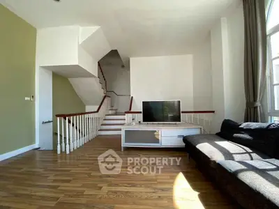 Spacious living room with modern staircase and natural light