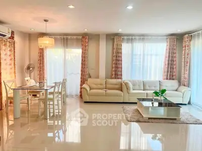 Spacious and elegant living room with modern furniture and abundant natural light.