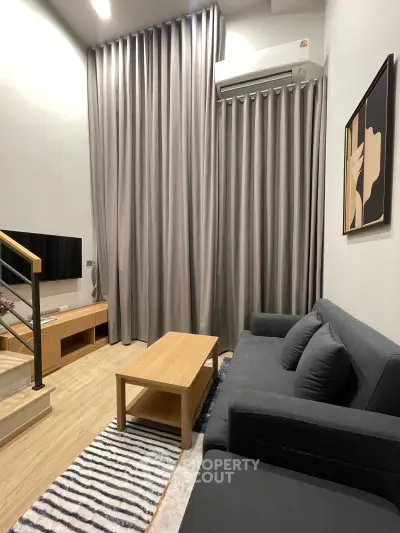 Modern living room with sleek furniture and stylish decor, featuring a cozy sofa and elegant curtains.