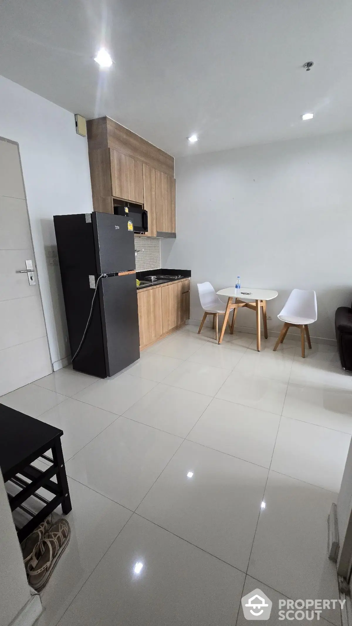 Modern kitchen with sleek cabinetry and dining area in contemporary apartment