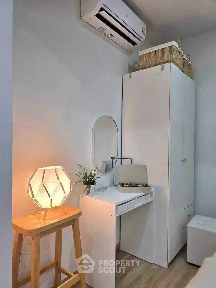 Cozy study nook with modern desk, stylish lamp, and air conditioning in a compact room.
