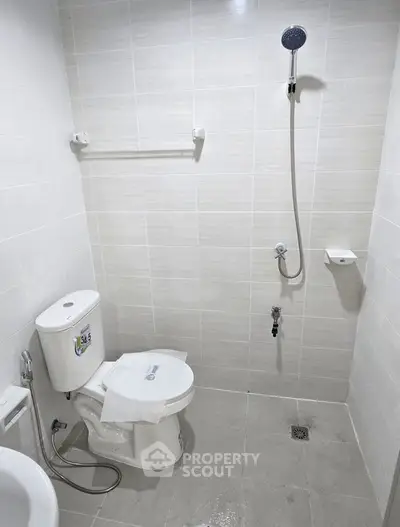 Modern bathroom with sleek white tiles and shower setup