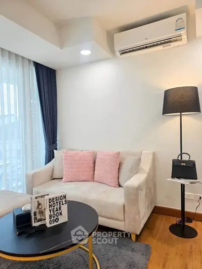 Cozy living room with modern decor and air conditioning, perfect for relaxation.