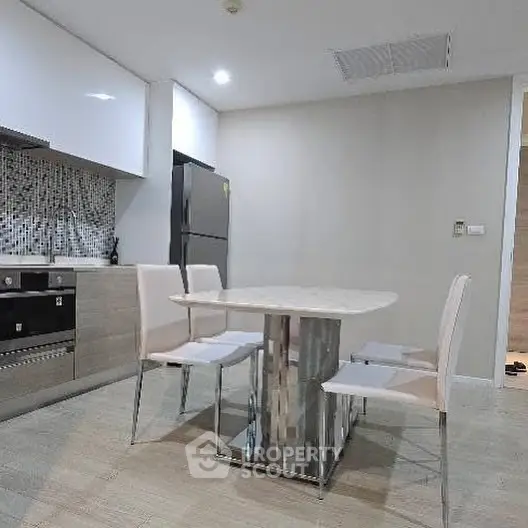 Modern kitchen with sleek dining area and stainless steel appliances.
