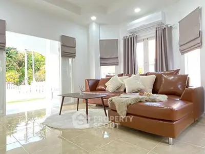 Elegant living room with leather sofa, modern decor, and natural light in a stylish home.