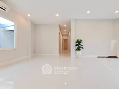 Spacious modern living room with glossy white tiles and natural light