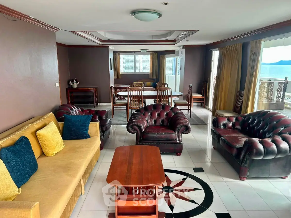 Spacious living room with elegant leather furniture and stunning ocean view.