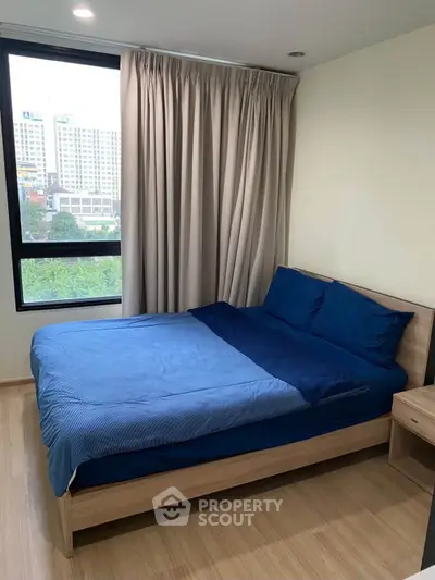 Cozy bedroom with modern decor and large window offering city view