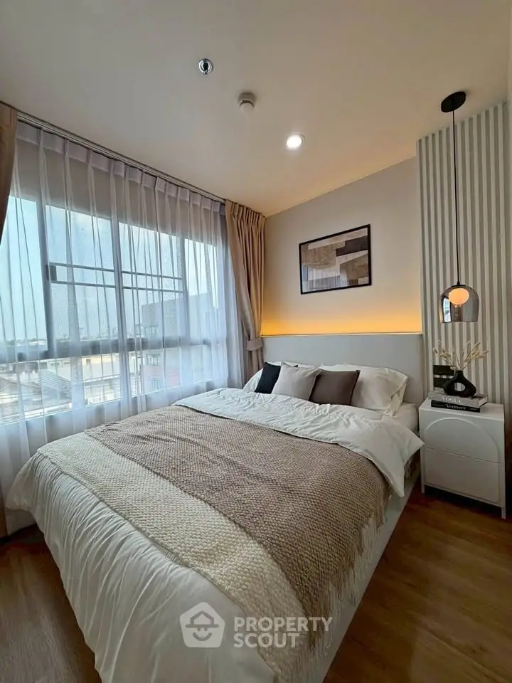 Cozy bedroom with large window and modern decor, perfect for relaxation and comfort.