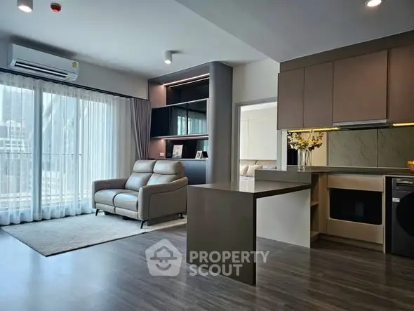 Modern open-plan living room and kitchen with sleek design and natural light.