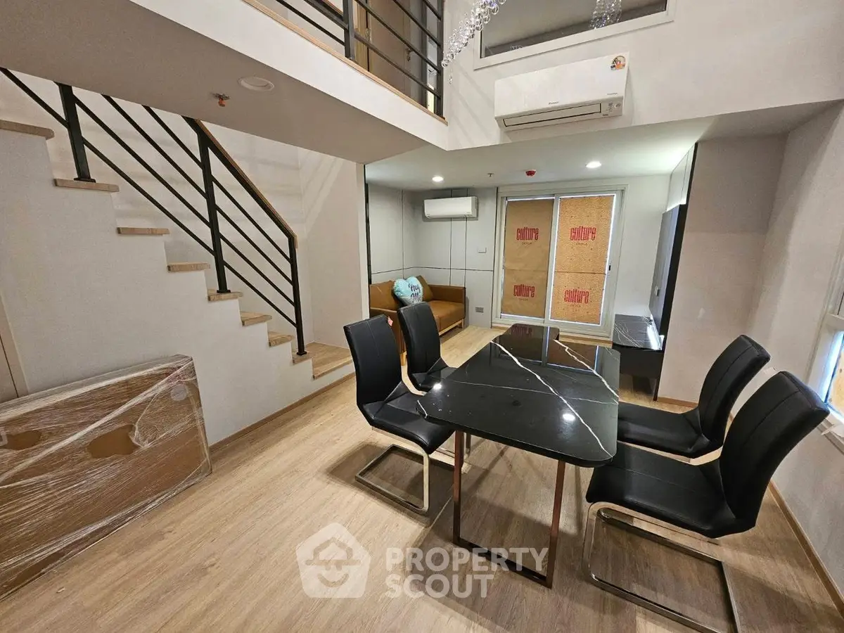 Modern duplex living room with stylish dining area and staircase