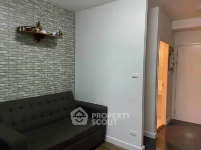 Cozy living room with modern gray sofa and brick accent wall, perfect for relaxation.