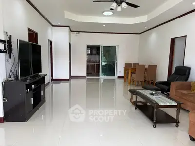 Spacious living room with modern furniture and large TV, perfect for family gatherings.