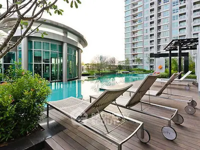 Luxurious apartment complex with modern poolside and sun loungers, perfect for relaxation and leisure.
